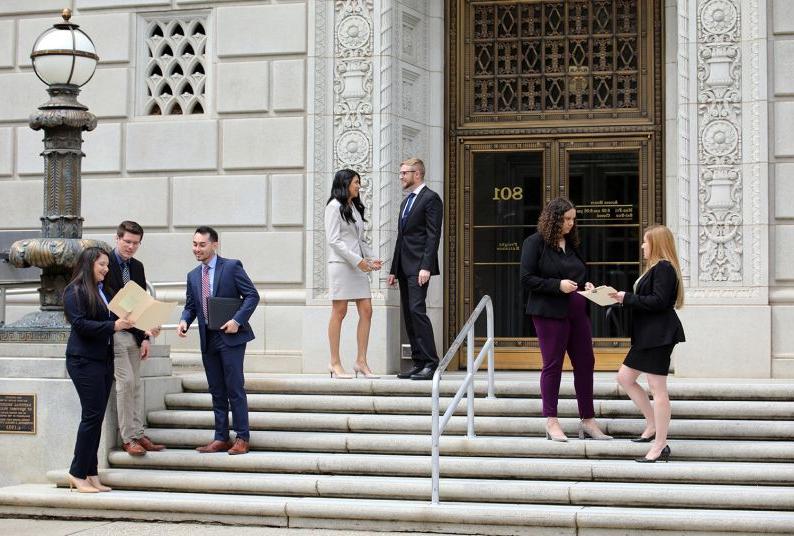 Law students stand on the steps of the Capitol building.
