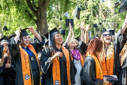 在毕业典礼上，学生运动员将他们的毕业帽抛向空中